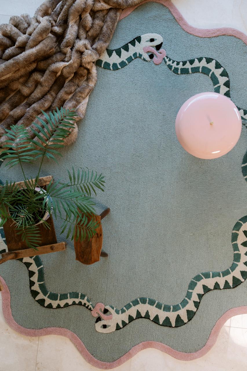 large round wool snake rug lying on the floor with lamp and blanket, statement rugs in south africa