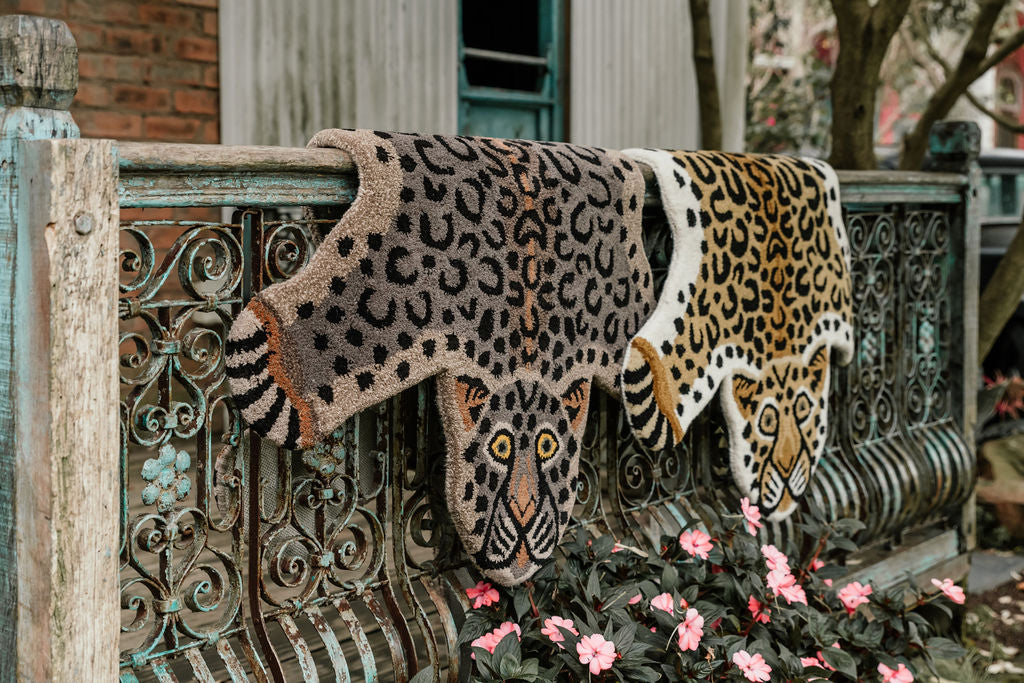 two leopard shaped rugs hanging on a wall, leopard print statement rugs