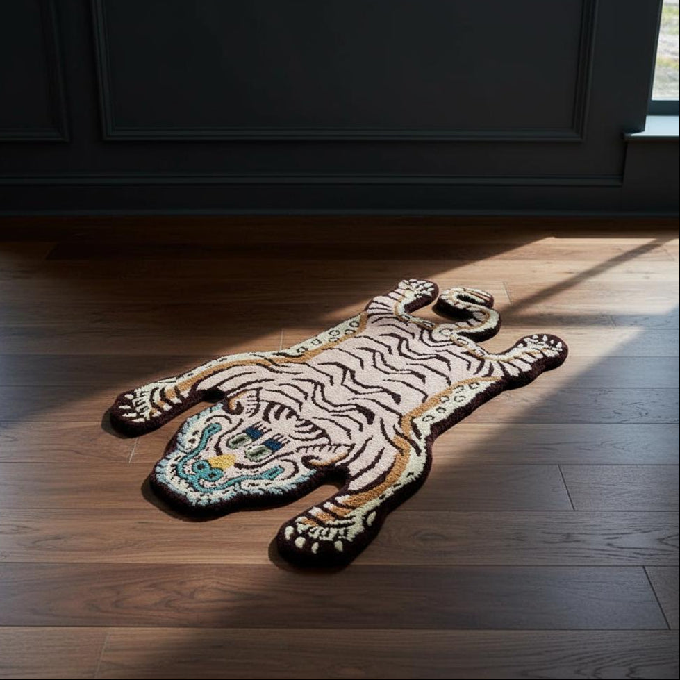 A tiger-shaped area rug with a pink and black striped pattern and turquoise accents, displayed on a dark wood floor in a room with a dark paneled wall and sunlight streaming in.