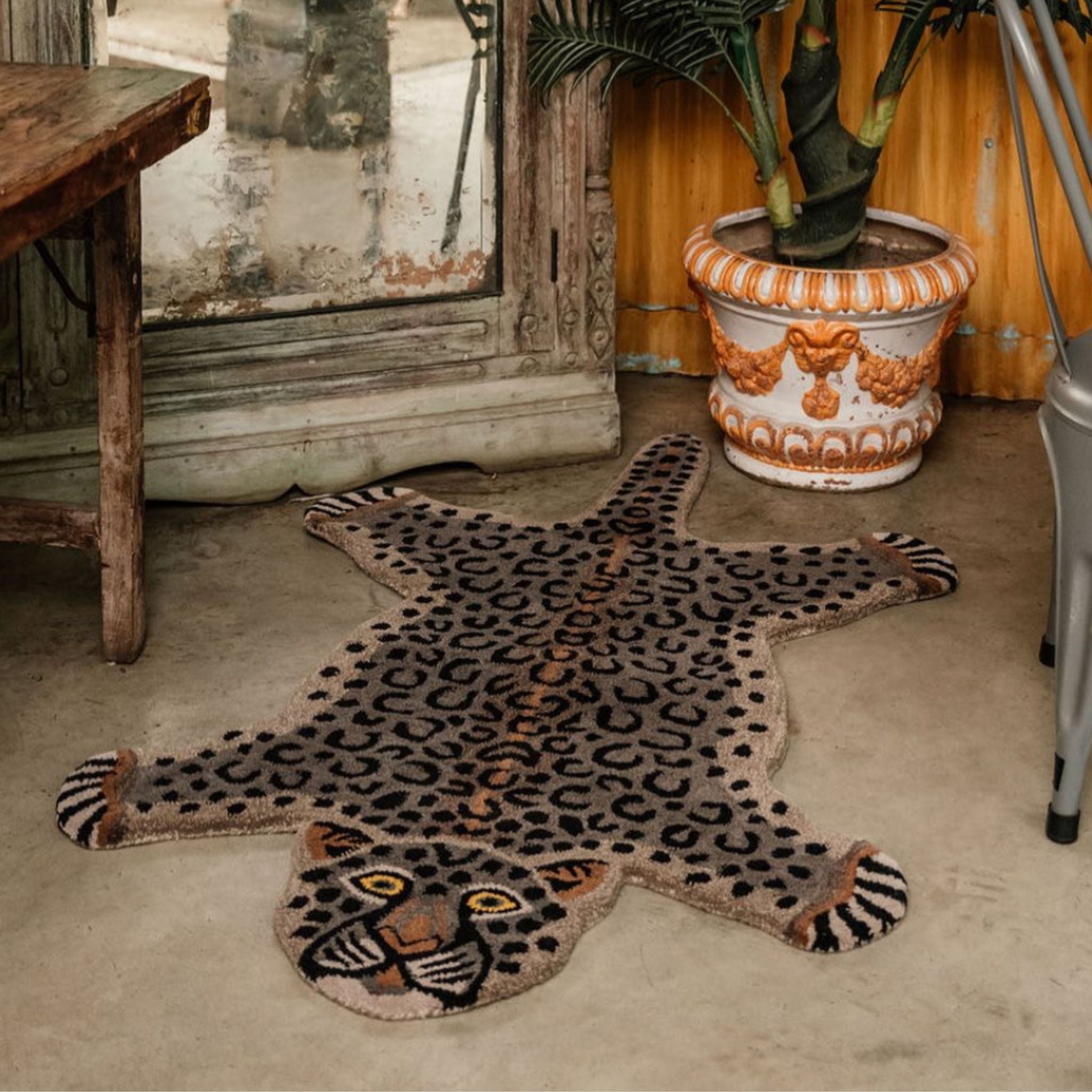 Hand-tufted wool Leopard print statement rug on a concrete floor with a rustic South African setting