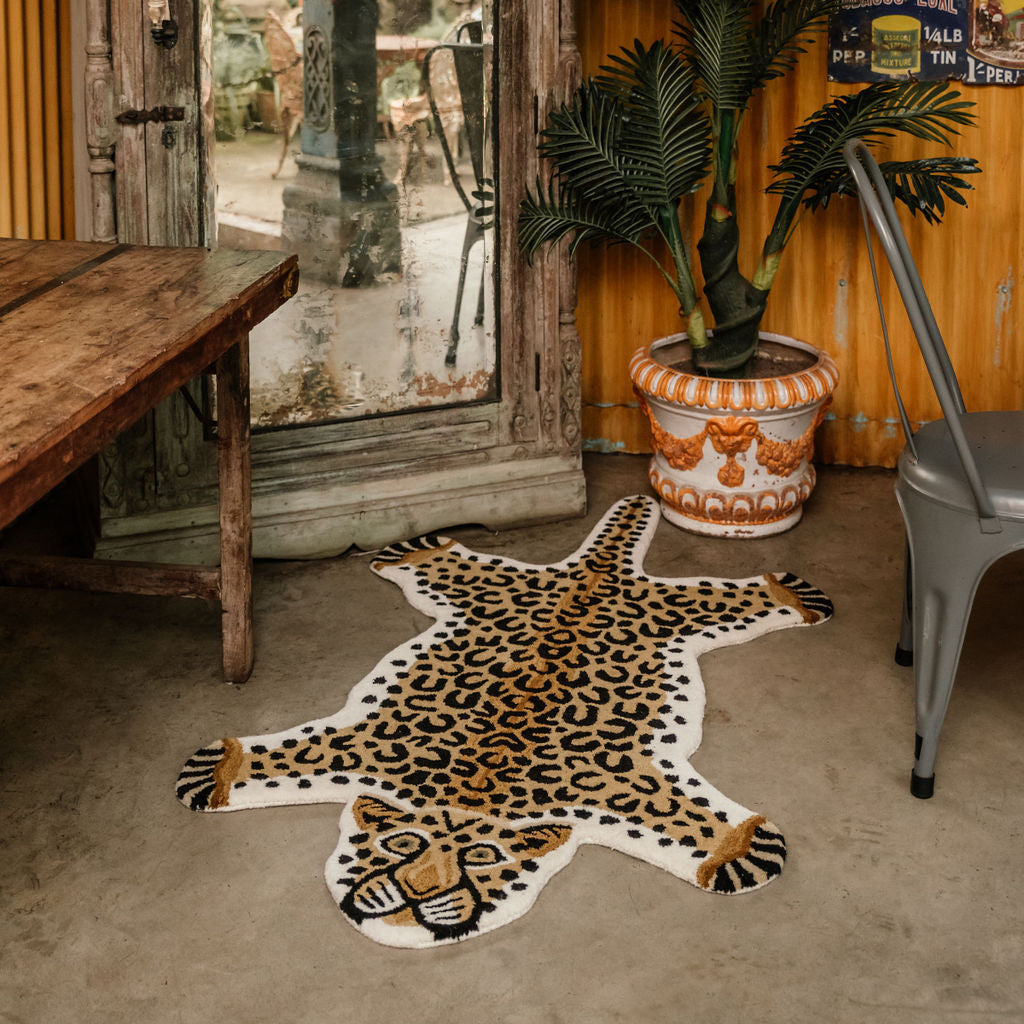 A hand-tufted leopard print wool statement rug laid out on the floor