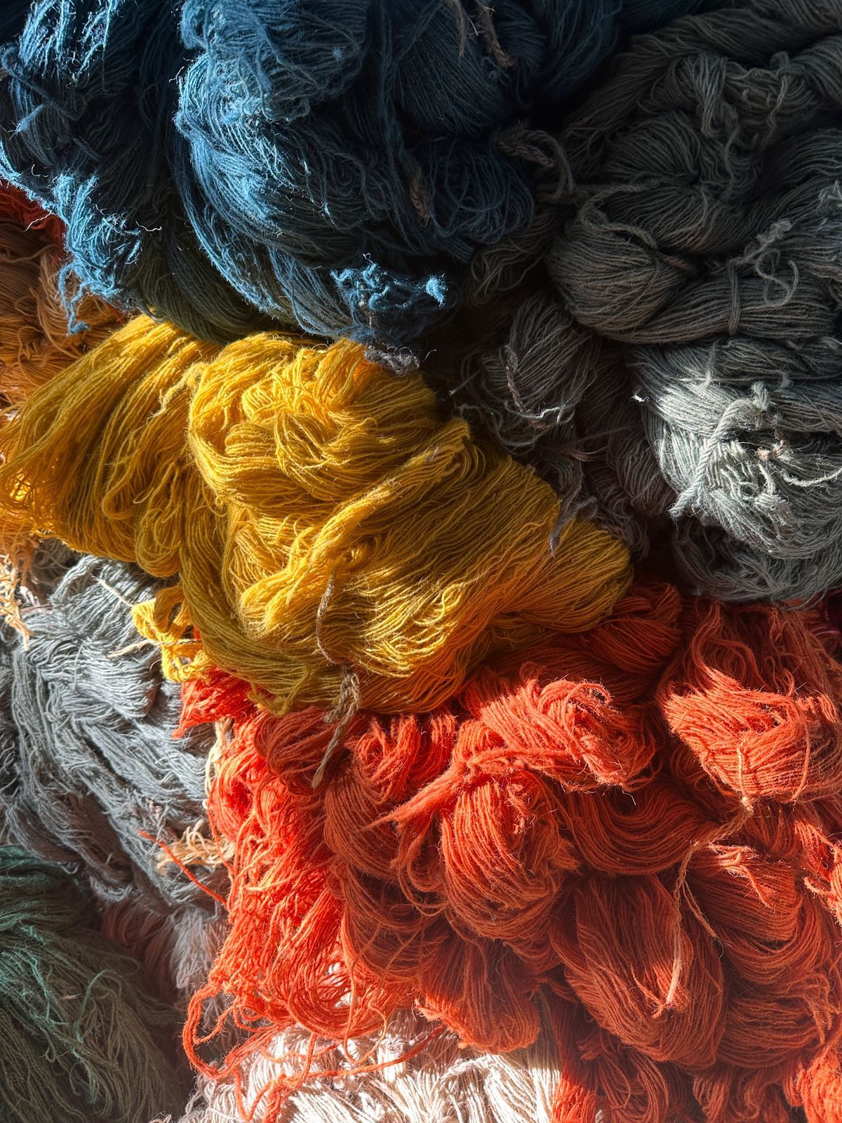 Close-up of colorful wool yarn skeins in blue, yellow, orange, and red.