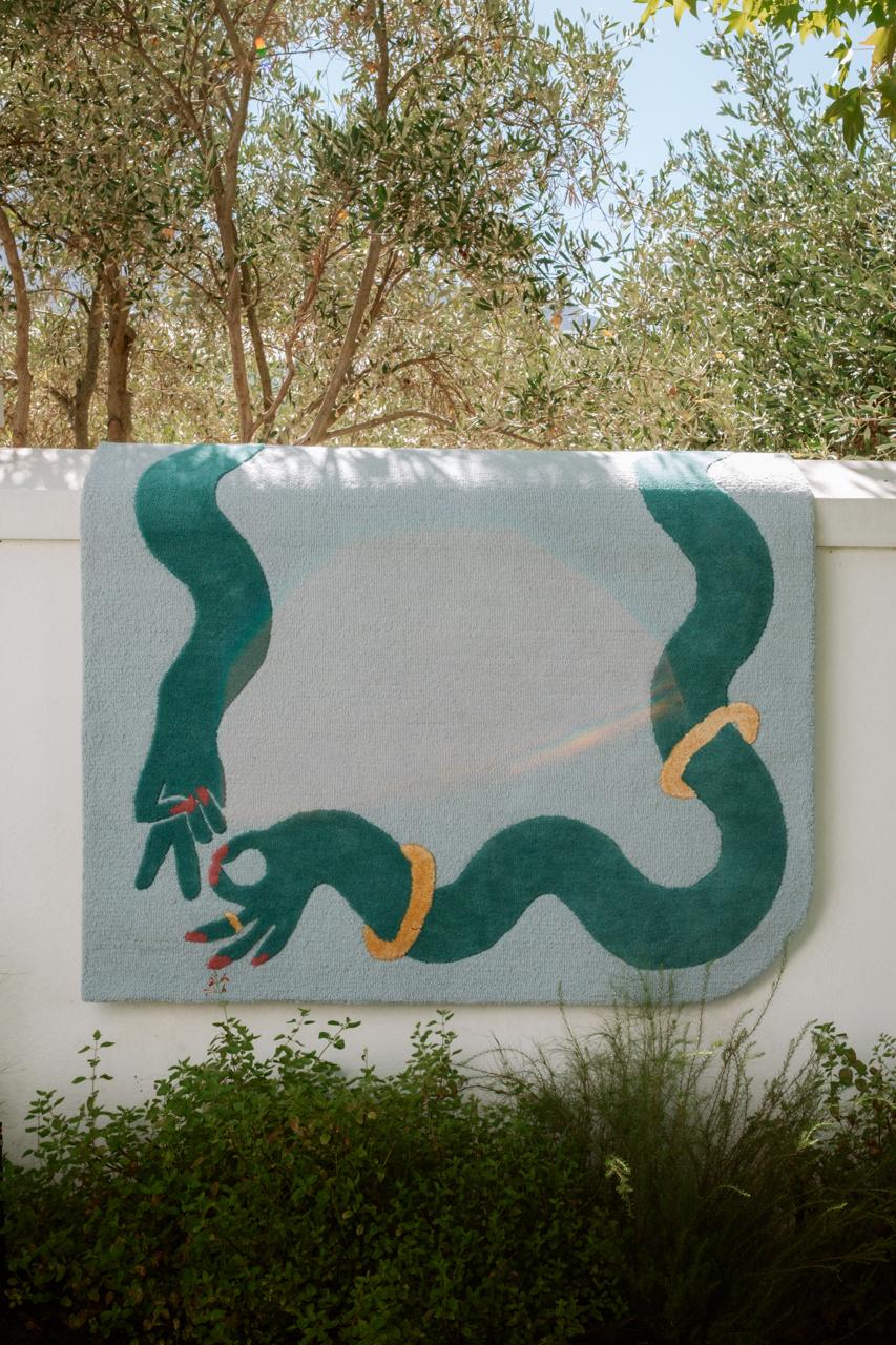 Large blue rug with a green wavy border and subtle gold silk accents