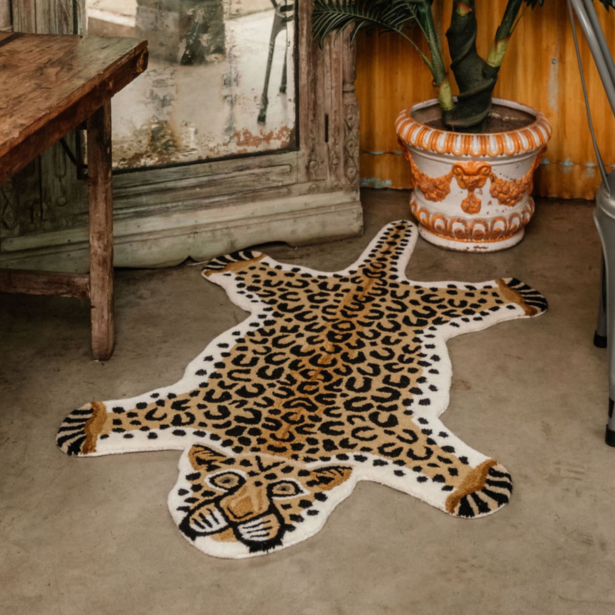A hand-tufted leopard print wool statement rug laid out on the floor 