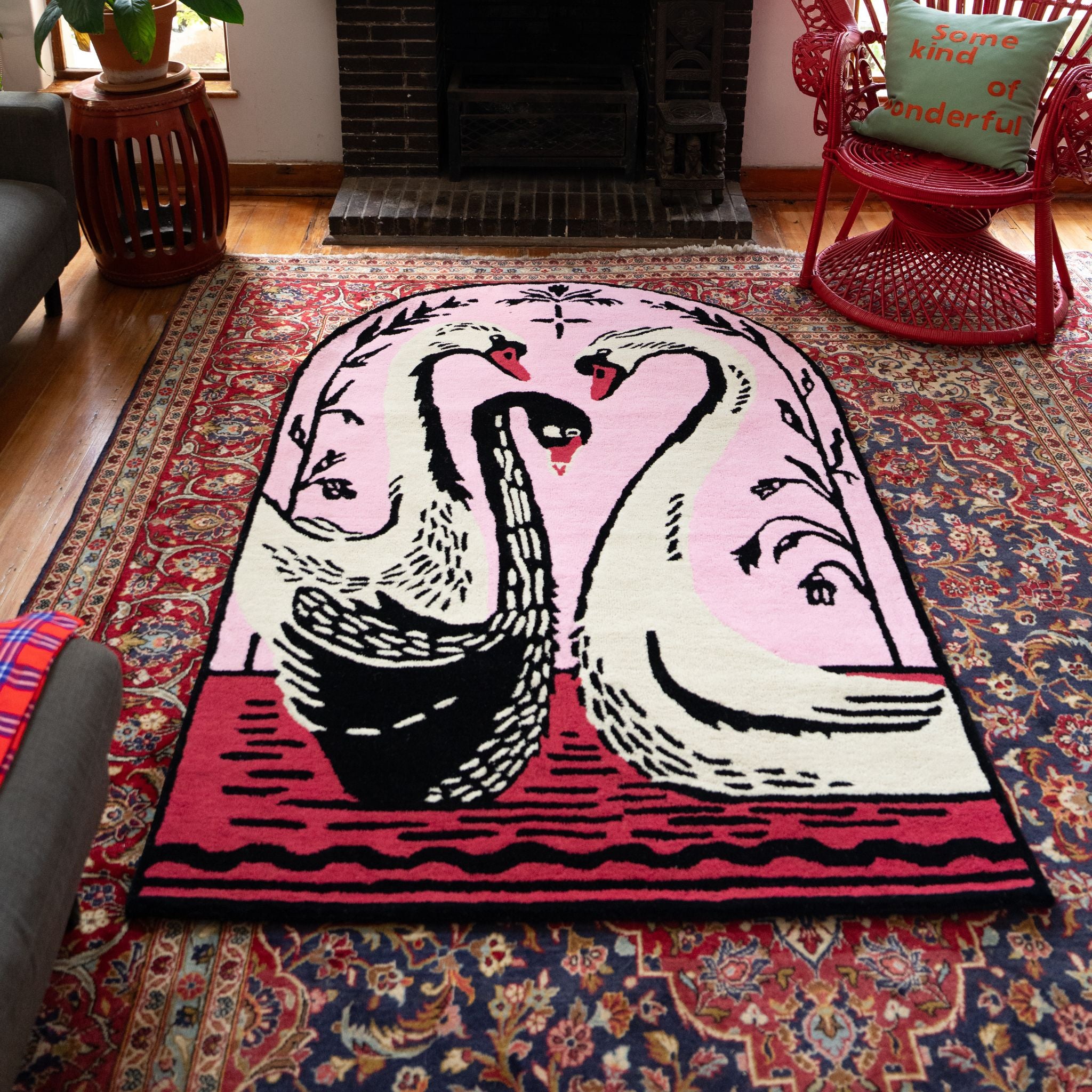 Decorative hand-tufted wool rug with swan design on a patterned floor